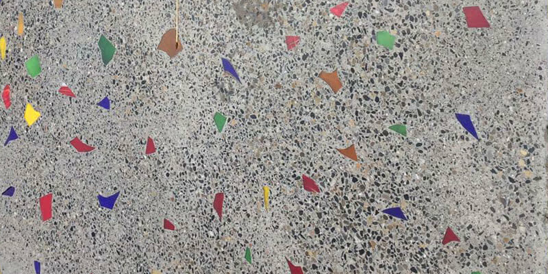 Polished concrete sample with coloured glass and brass strip