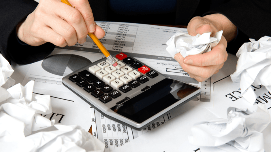 Someone using a calculator with crumbled paper