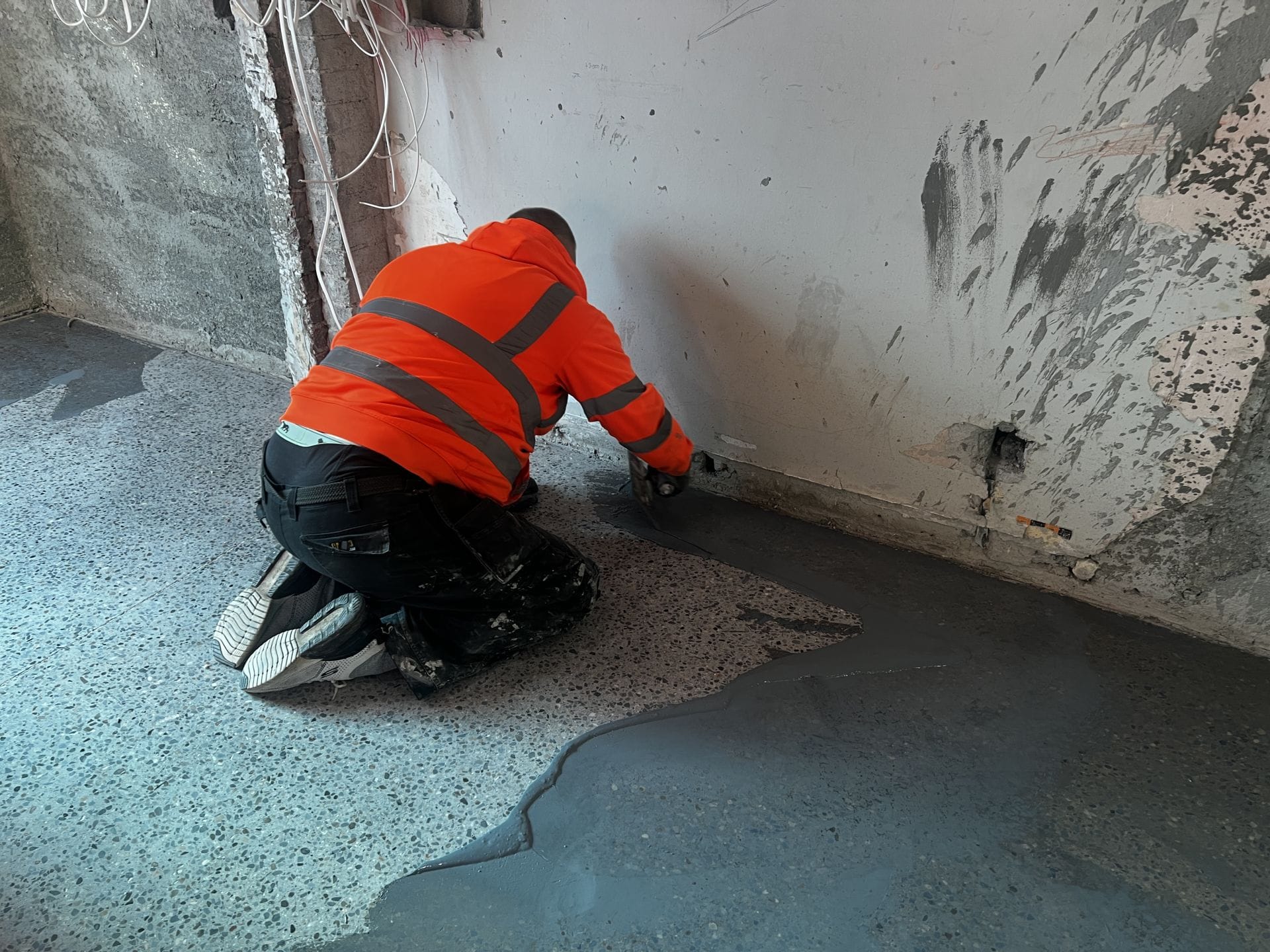 PMAC operative filling micro holes with cement on platinum finish polished concrete floor