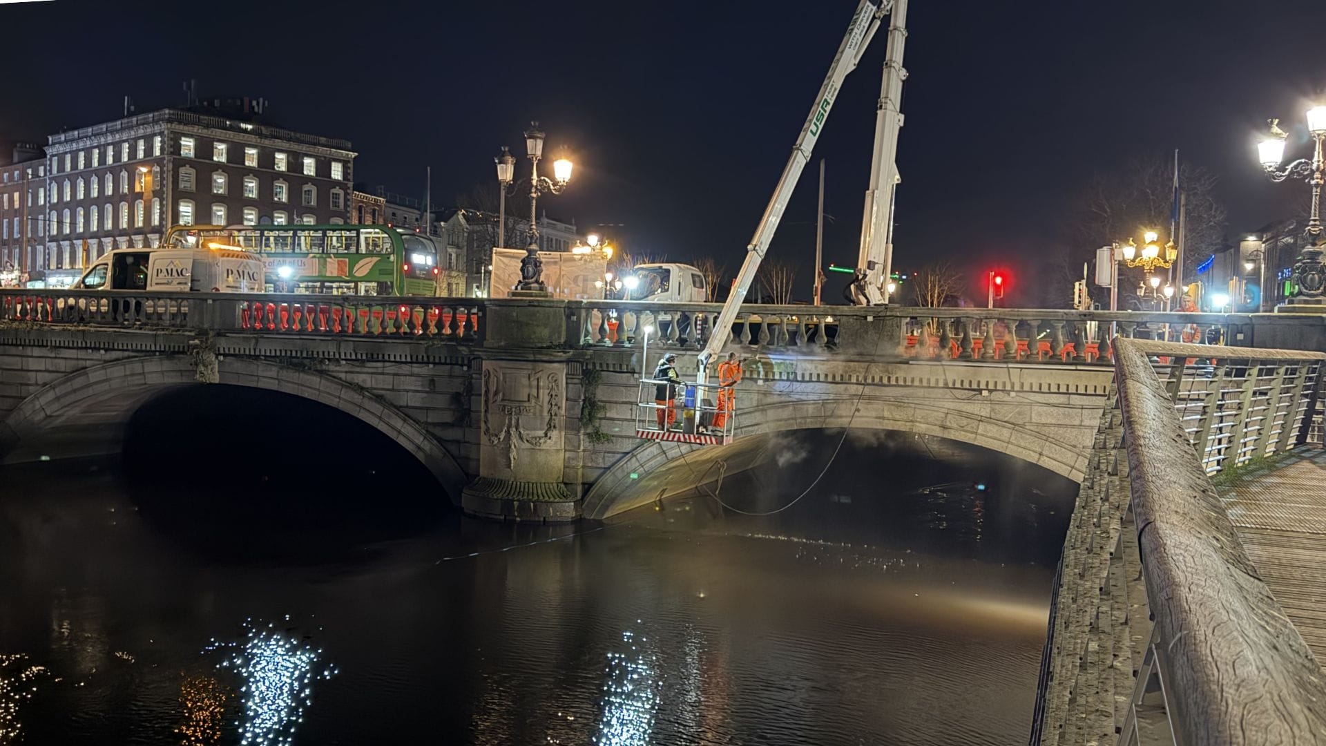 PMAC using a hoist at night to clean O'Connell Bridge in Dublin